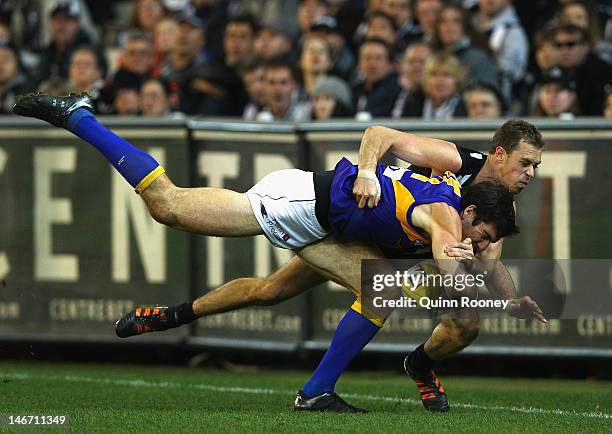 Quinten Lynch of the Eagles is tackled by Nick Maxwell of the Magpies during the round 13 AFL match between the Collingwood Magpies and the West...