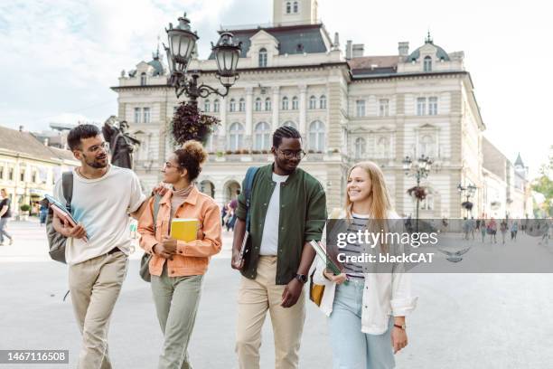 fröhliche multiethnische gruppe von studenten auf der straße - austauschstudent stock-fotos und bilder