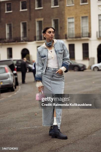 Gabriella Berdugo wearing a light blue denim maxi skirt, white Prada tank, pale beige shirt, light pale pink Chanel bag, and blue denim rose neck...