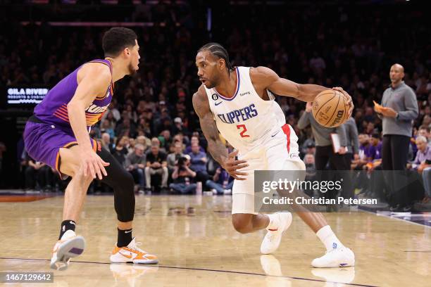 Kawhi Leonard of the LA Clippers handles the ball against Devin Booker of the Phoenix Suns during the second half of the NBA game at Footprint Center...