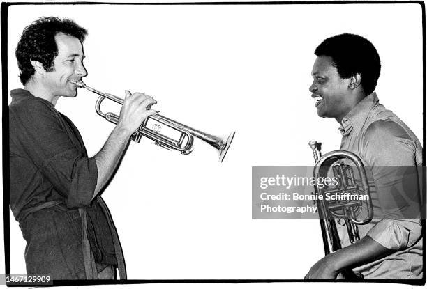 Musicians Herb Alpert and Hugh Masekela face each other in black and white with their trumpets in Los Angeles in 1977.