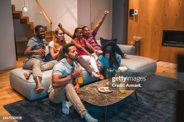 young mixed race people watching sports in a living room - messy boyfriend stock pictures, royalty-free photos & images