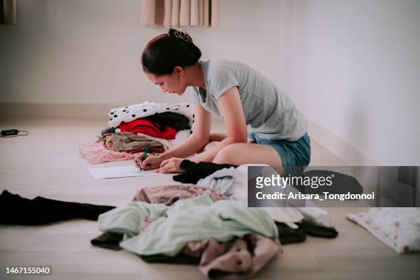 woman taking her clothes to sell and is calculating the money that will be received from the sale - secondhand försäljning bildbanksfoton och bilder