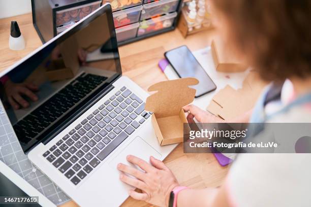 the seller prepares the delivery box for the customer with a laptop - parcel laptop stock pictures, royalty-free photos & images
