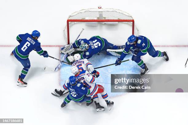 Arturs Silovs makes a save as teammates, Brock Boeser, Sheldon Dries and Ethan Bear of the Vancouver Canucks, defend against Jake Leschyshyn and...