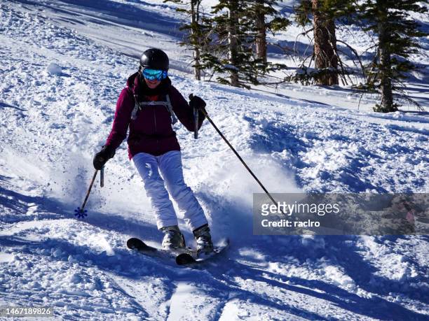 mature woman skier spraying snow. snowmass ski resort, aspen, colorado. - snowmass stock pictures, royalty-free photos & images