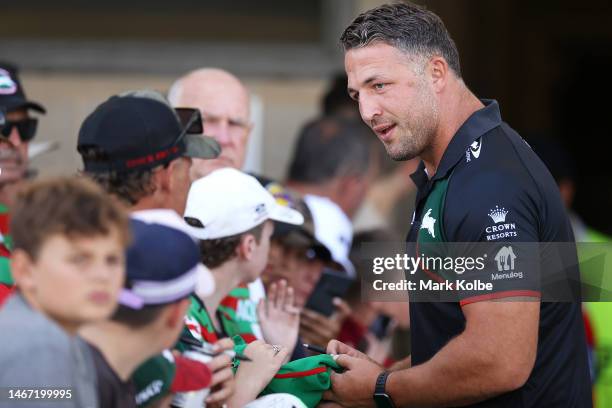 Sam Burgess of the Rabbitohs coaching staff signs autographs during the NRL Trial and Charity Shield match between St George Illawarra Dragons and...