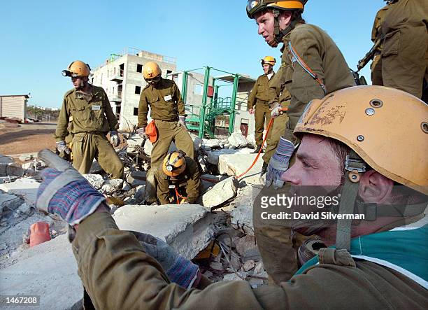 Israeli soldiers try free a "victim" from a collapsed building during a training exercise October 9, 2002 at an Israeli army Home Front Command...