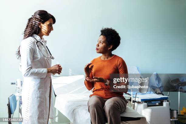 woman talking with the doctor about a flu shot - doctor speech stock pictures, royalty-free photos & images