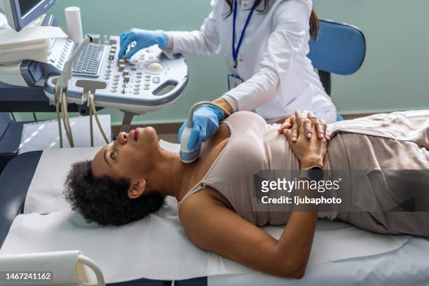 arzt, der ultraschall der schilddrüse an eine patientin in der klinik macht - thyroid gland stock-fotos und bilder