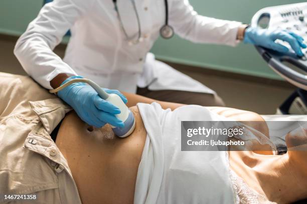 médico examinador mujer madura con dispositivo de escáner de ultrasonido - hígado humano fotografías e imágenes de stock