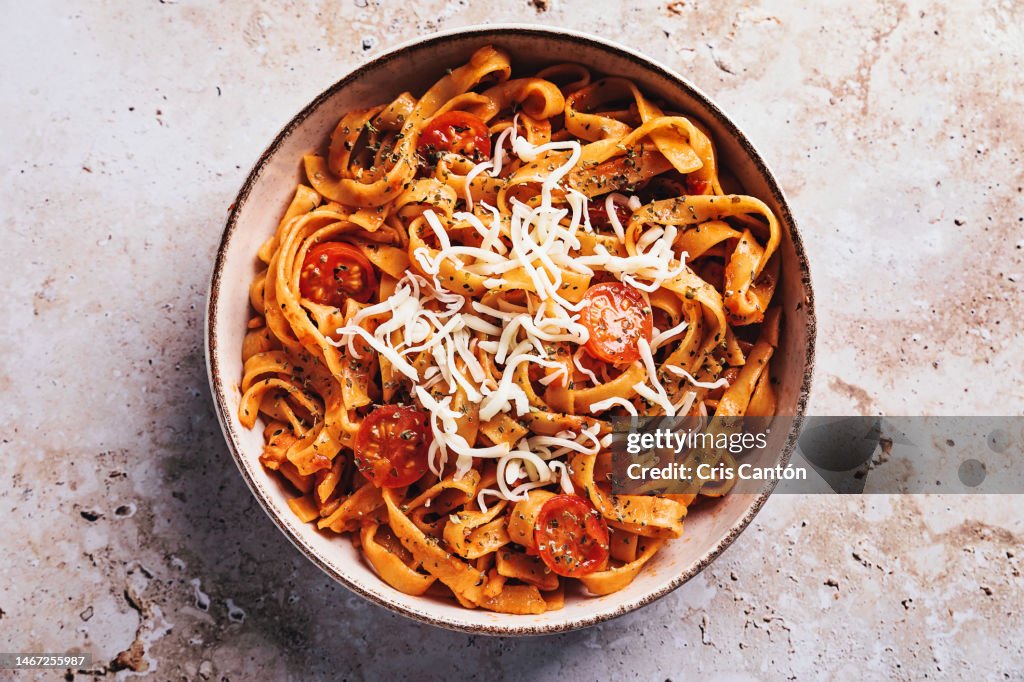 Tagliatelle with tomato sauce on stone background