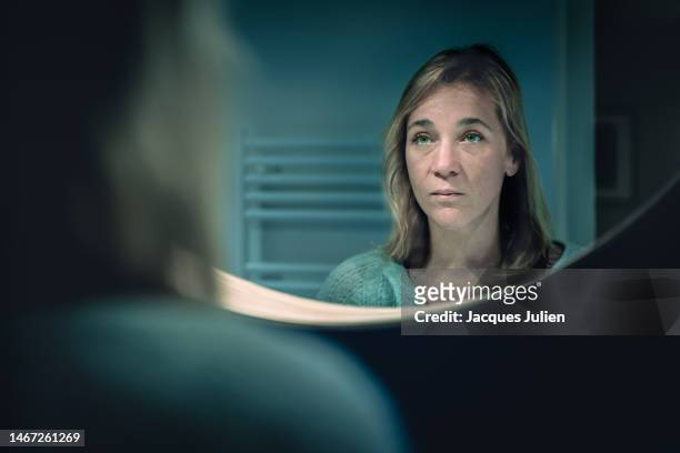 sad woman in mirror portrait - woman mirror stockfoto's en -beelden