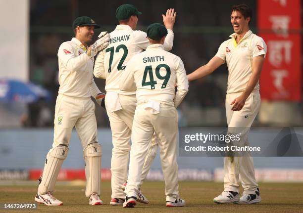 Pat Cummins of Australia celebrates taking the wicket of Ravichandran Ashwin of India during day two of the Second Test match in the series between...