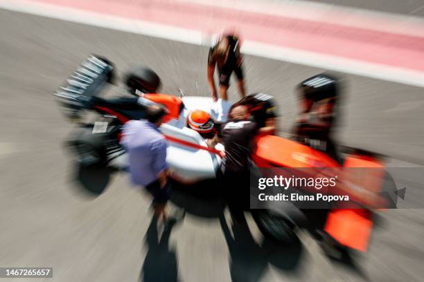 defocused race car and team working on pit stop moment - car racing blurred motion stock pictures, royalty-free photos & images