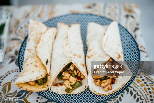 wrapped chicken burritos  on plate - fajita photos et images de collection