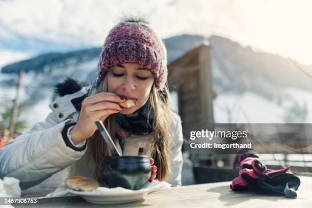 teenager genießen heiße gulaschsuppe in einem restaurant im freien an einem sonnigen wintertag. - après ski stock-fotos und bilder