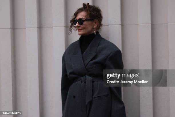 Renia Jaz seen wearing shades by Bottega Veneta, Chanel earrings, a bag by Yves Saint Laurent, a black transparent feather skirt, black high heels, a...