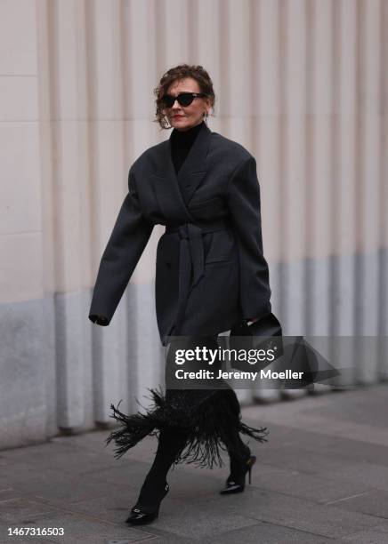 Renia Jaz seen wearing shades by Bottega Veneta, Chanel earrings, a bag by Yves Saint Laurent, a black transparent feather skirt, black high heels, a...