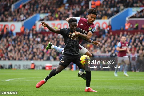 Bukayo Saka of Arsenal is challenged by Boubacar Kamara of Aston Villa before Oleksandr Zinchenko of Arsenal scored their sides second goal during...