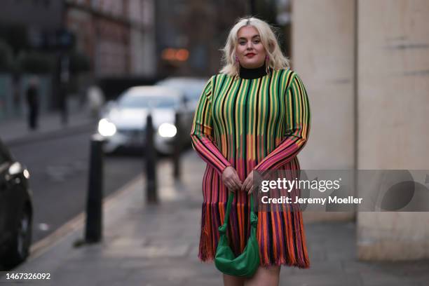 Felicity Hayward seen wearing a striped colourful fringe dress, a green bag and animal printed heels before the Mark Fast show during London Fashion...