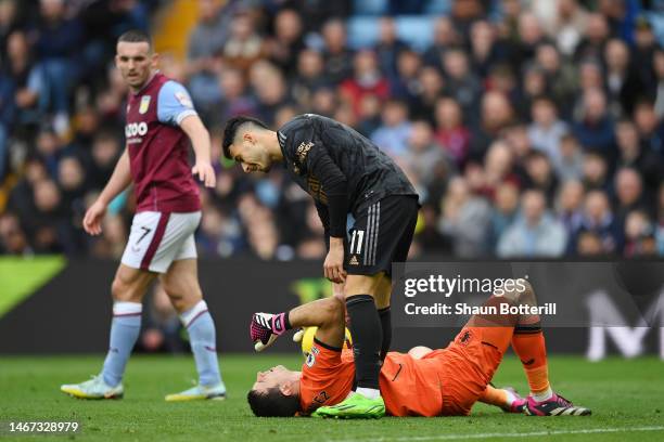 Gabriel Martinelli of Arsenal helps up Emiliano Martinez of Aston Villa during the Premier League match between Aston Villa and Arsenal FC at Villa...