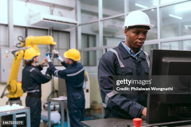 team engineer working automatic robotic arm machine in factory. - industrial plant stock pictures, royalty-free photos & images