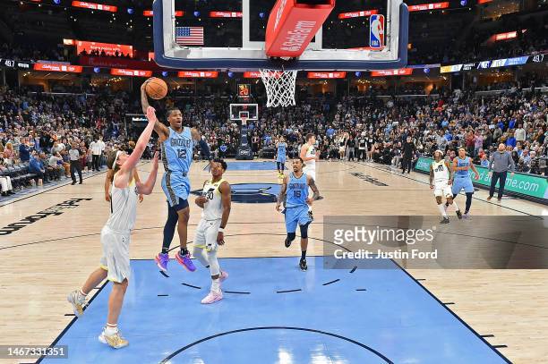 Ja Morant of the Memphis Grizzlies goes to the basket against Kelly Olynyk of the Utah Jazz during the game at FedExForum on February 15, 2023 in...