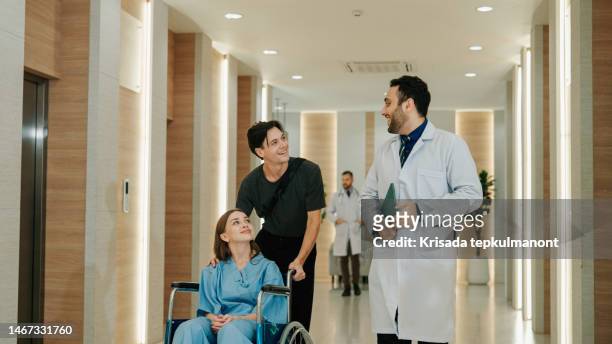adult doctor talking to patient and her boyfriend while escorting them out of hospital. - doctor leaving stock pictures, royalty-free photos & images