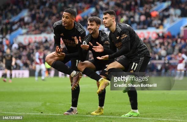 William Saliba, Fabio Vieira and Gabriel Martinelli of Arsenal celebrate after their sides fourth goal during the Premier League match between Aston...
