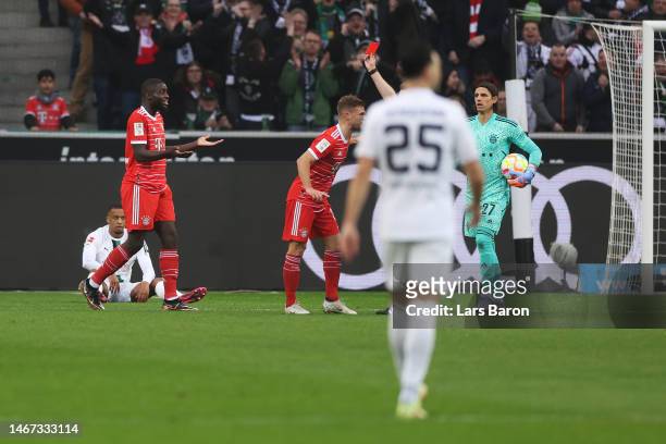 Referee Tobias Welz shows a red card to Dayot Upamecano of FC Bayern Munich during the Bundesliga match between Borussia Mönchengladbach and FC...