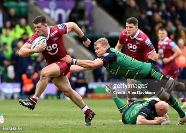 Tom Curry of Sale Sharks breaks past David Ribbans and Aaron Hinkley of Northampton Saints on the way to scoring his sides 2nd try during the...