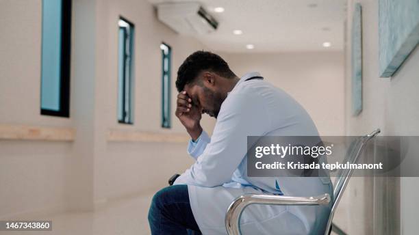 a doctor who is faced with many cases of severely ill or injured patient may become intensely stressed. - patient in hospital stock pictures, royalty-free photos & images