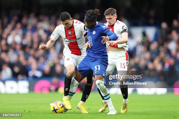 Noni Madueke of Chelsea runs with the ball whilst under pressure from Romain Perraud and Mohamed Elyounoussi of Southampton during the Premier League...