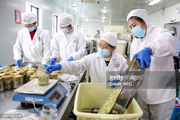 Employees package processed tea leaves on a production line at a tea processing factory on February 18, 2023 in Tonglu County, Hangzhou City,...
