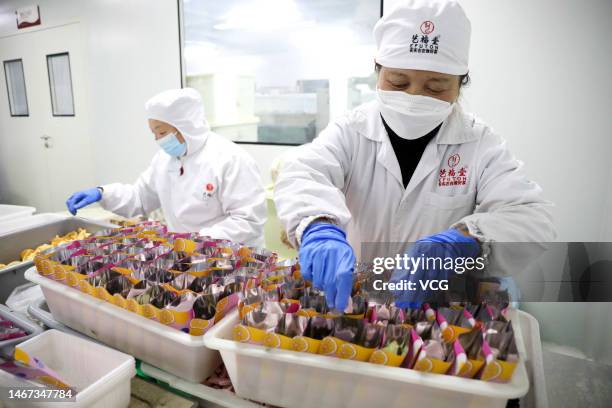 Employees package processed tea leaves on a production line at a tea processing factory on February 18, 2023 in Tonglu County, Hangzhou City,...