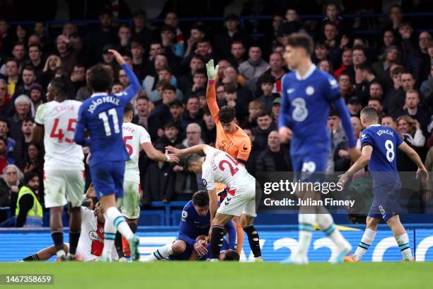 Ben Chilwell of Chelsea kneels down to tend to Cesar Azpilicueta as they lie on the floor with a potential head injury, as Mohamed Elyounoussi of...