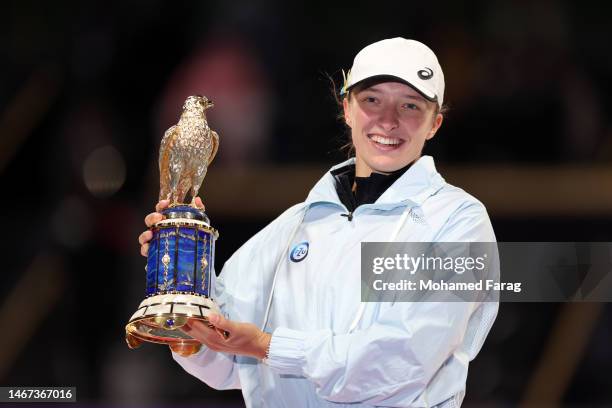 Iga Swiatek of Poland celebrates with the trophy on the podium after defeating Jessica Pegula of USA in the final match on day six of the Qatar Total...