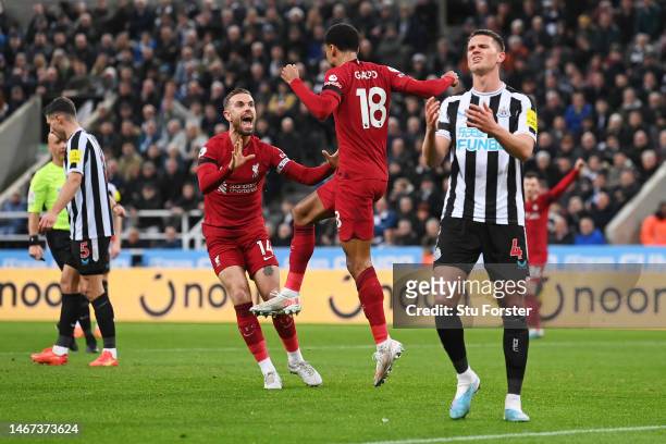 Cody Gakpo of Liverpool celebrates with teammate Jordan Henderson after scoring the team's second goal as Sven Botman of Newcastle United looks...