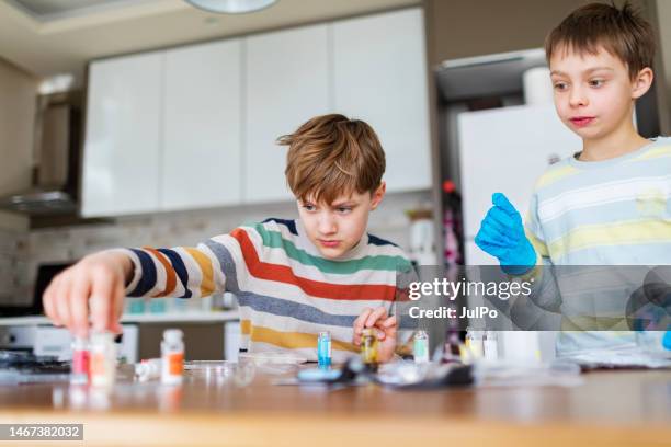 dois meninos que fazem o experimento químico da ciência em casa - washing up glove - fotografias e filmes do acervo