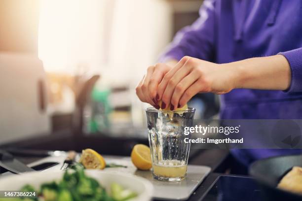 jugendliche kochen mittagessen für die ganze familie - zitronensaft stock-fotos und bilder