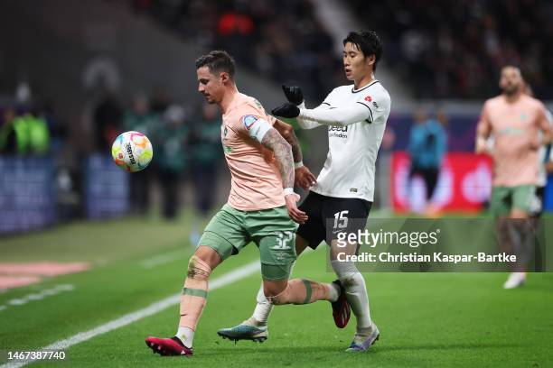 Marco Friedl of SV Werder Bremen is challenged by Daichi Kamada of Eintracht Frankfurt during the Bundesliga match between Eintracht Frankfurt and SV...