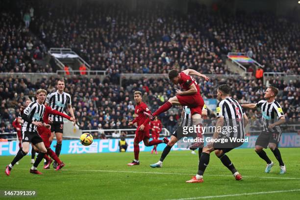 Diogo Jota of Liverpool shoots while under pressure from Fabian Schaer and Matt Ritchie of Newcastle United during the Premier League match between...