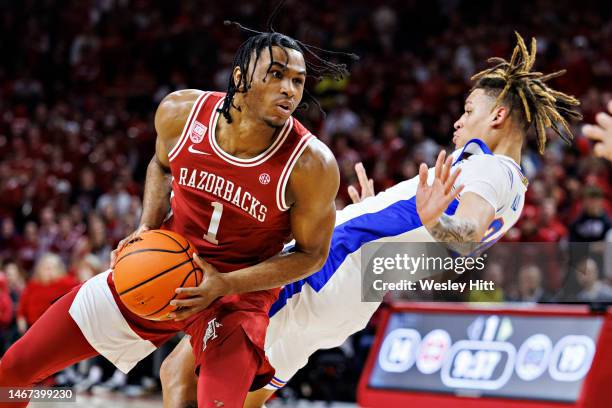 Ricky Council IV of the Arkansas Razorbacks drives to the basket in the first half and is called for a charge against Riley Kugel of the Florida...