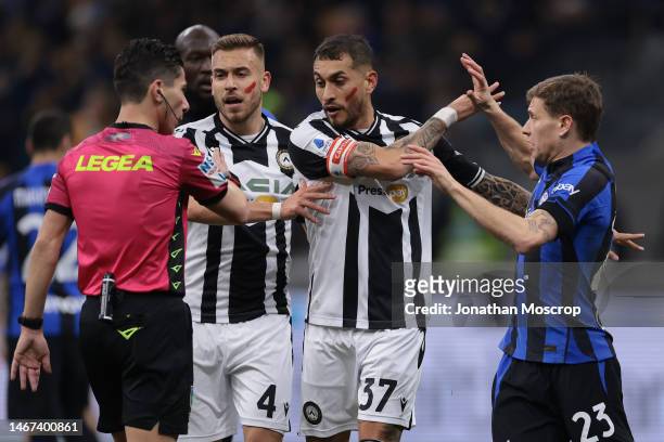 Nicolo Barella of FC Internazionale is pushed away by Roberto Pereyra of Udinese Calcio as he appeals to the Referee Federico Dionisi for a penalty...