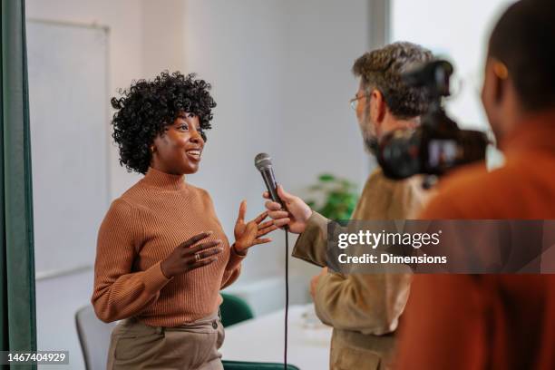 cheerful office worker being interviewed by tv crew. - female politicans stock pictures, royalty-free photos & images