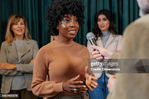 joyful businesswoman being interviewed in company. - news crew stock pictures, royalty-free photos & images