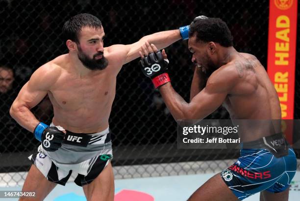 Khusein Askhabov of Russia punches Jamall Emmers in a featherweight fight during the UFC Fight Night event at UFC APEX on February 18, 2023 in Las...
