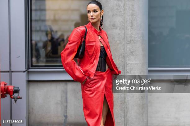 Brazilian model Sofia Resing wears red leather jacket, long skirt with slit, black transparent body, pointed heels with silver outside David Koma...