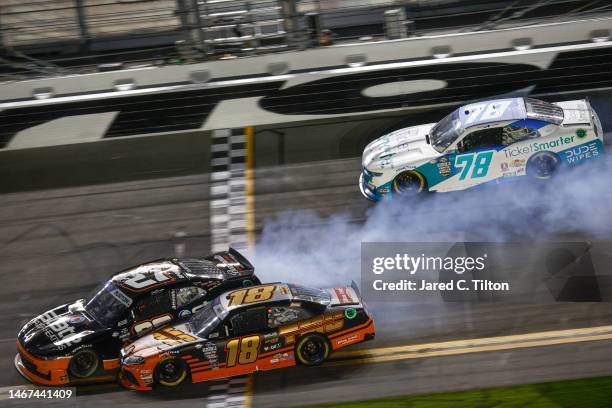 Sammy Smith, driver of the TMC Toyota, and Jeb Burton, driver of the State Water Heaters Chevrolet, spin after an on-track incident during the NASCAR...